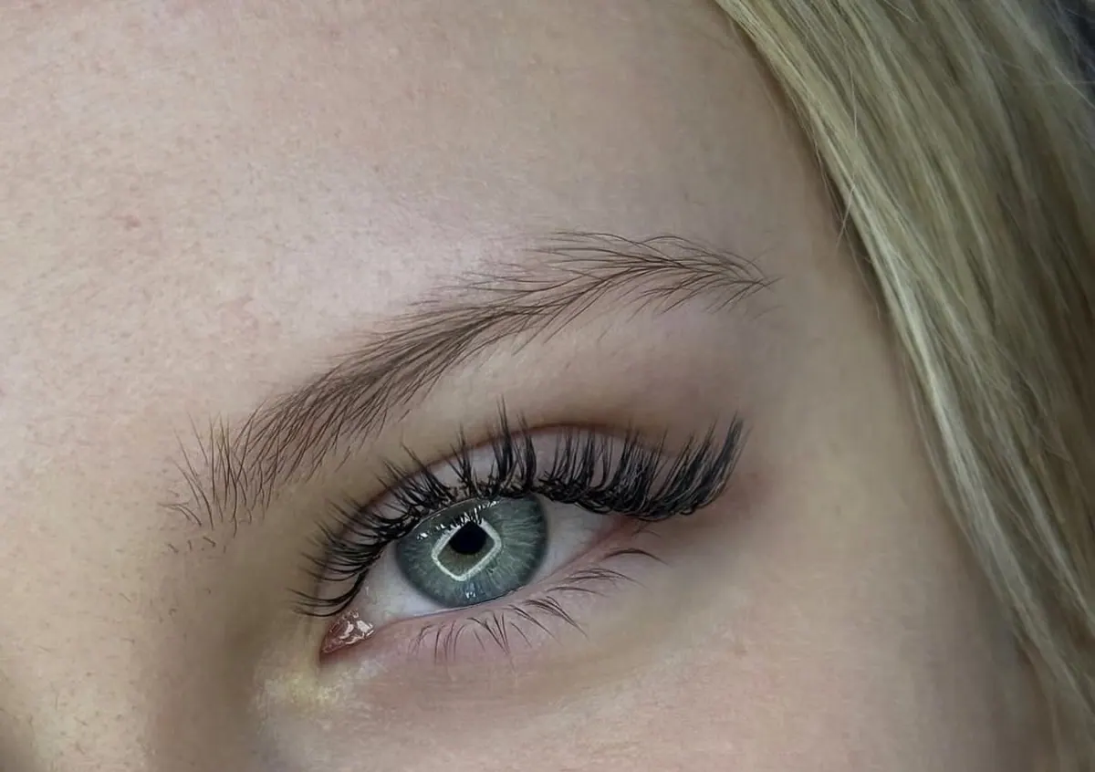 Wimpernverlängerung mit natürlich wirkendem Schwung an einem blauen Auge